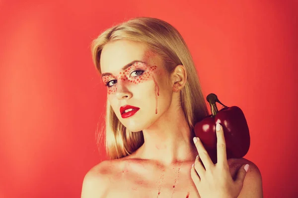 Mooie blonde vrouw met creatieve modieuze make-up greep paprika — Stockfoto