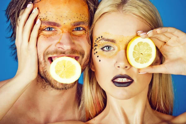 woman and happy man with makeup hold lemon