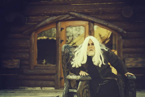 Old wizard in wooden chair