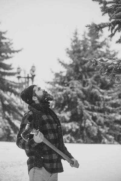 Man met baard in winter forest met sneeuw houdt bijl. — Stockfoto