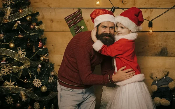 Santa claus kid en bebaarde man bij kerstboom. — Stockfoto