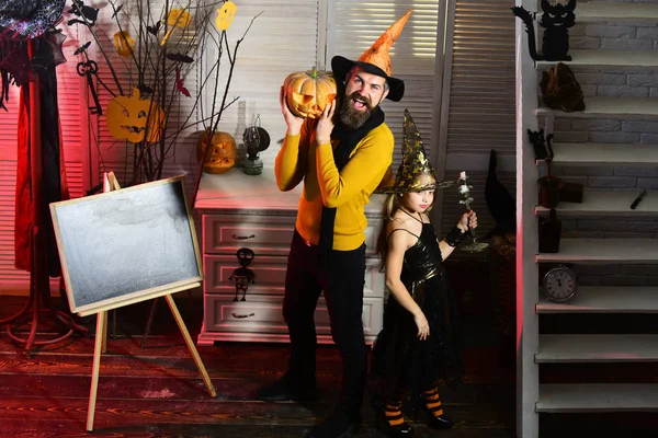 Wizard and little witch hold pumpkin and candlestick — Stock Photo, Image