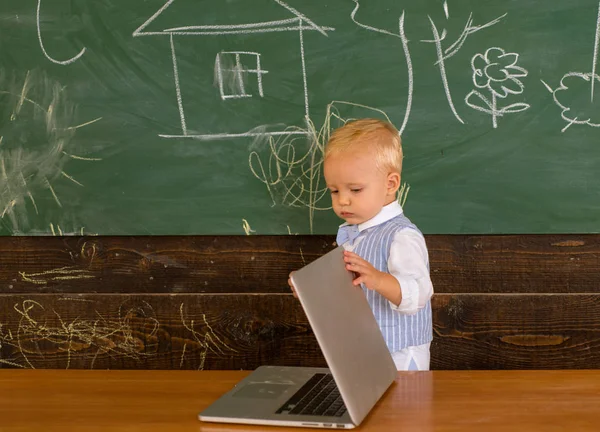 Peuter hebben toegang tot het draadloze internetverbinding in school klas. Kleine jongen toegang tot gratis internet in de computer klasse — Stockfoto