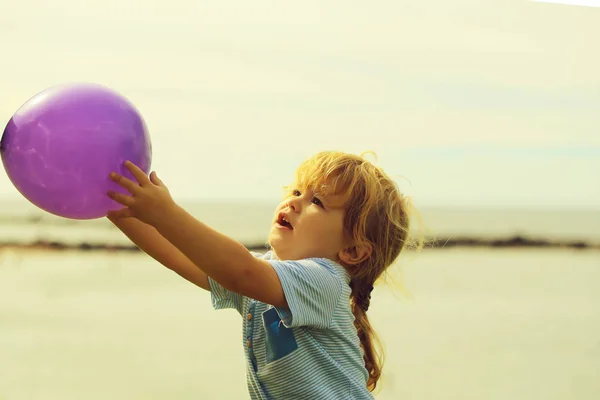 かわいい男の子の手で紫の風船を保持します。 — ストック写真