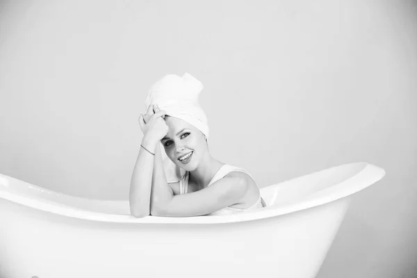 リラックスと衛生、白い浴槽にタオル ターバンを持つ女性 — ストック写真