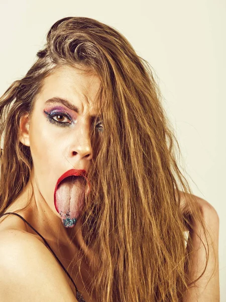 Beautiful girl with bright make up, fashionable hairstyle showing tongues — Stock Photo, Image