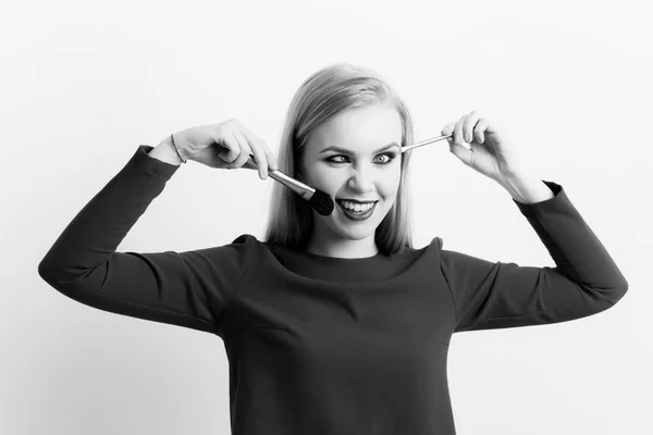 Chica entrecerrando los ojos en cara tonta con pinceles de maquillaje —  Fotos de Stock