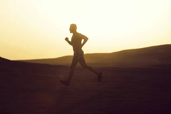 Man runner uitgevoerd in Duin bij zonsondergang — Stockfoto