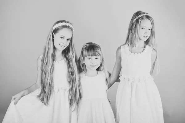Döttrar spelar i studioe. De står nära är den rosa väggen. Begreppet vänlig familj. — Stockfoto