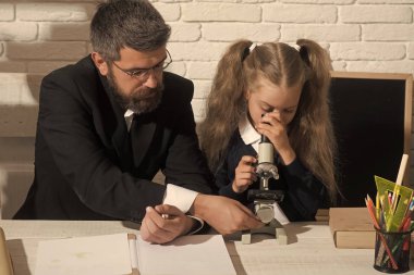 Kız ve erkek Resepsiyon tarafından oturup mikroskop bakmak