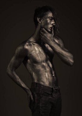 Adam kendine güvenen seksi ifade ile poz tutan parmak dudaklarından.