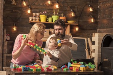 Aile oyun kurucu, plastik tuğla ayrıntılarını içeren. Anne ve çocuk uzun plastik blok tren kaldır. Baba oğul önünde plastik araba tutar. Ebeveynler için onların yakışıklı konuşmak