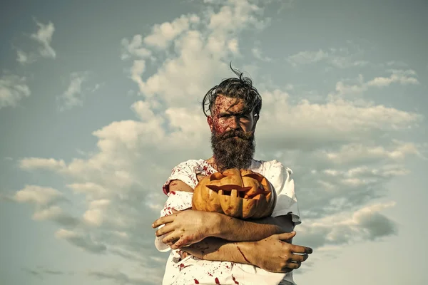 Halloween hipster hombre sosteniendo la calabaza en el cielo azul — Foto de Stock