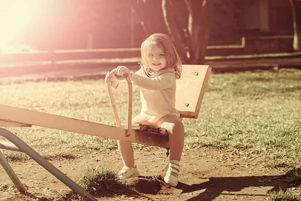 晴れた日にシーソーの女の子を笑顔します。 — ストック写真