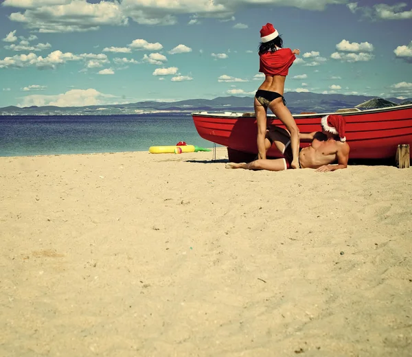 Casal de Natal em vermelho no barco de praia . — Fotografia de Stock