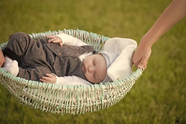 Filho criança dormindo na cesta na grama verde — Fotografia de Stock