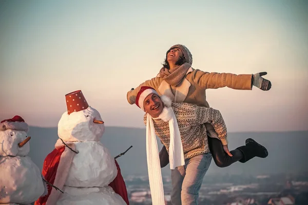 Santa musculoso hombre y chica con muñeco de nieve . — Foto de Stock