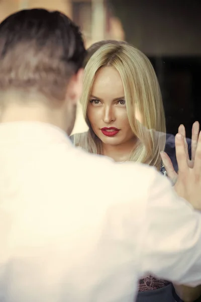 Woman with sensual lips look at men through glass window