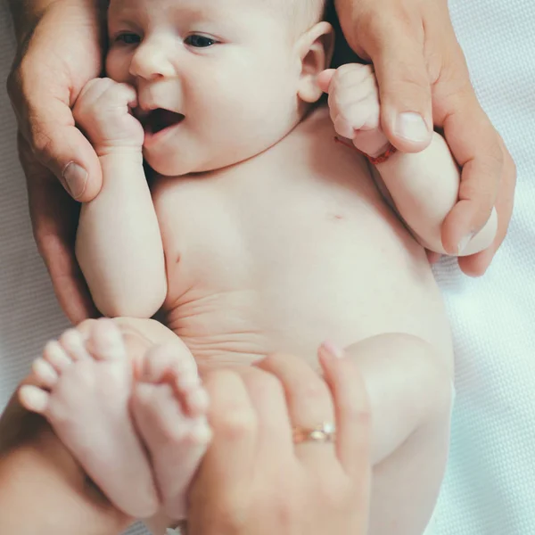Händerna som hand. Nyfött barn i föräldrar händer. Nyfött barn gett kroppsmassage. Kroppen hudvård. Hålla babys hud frisk. Känner gillar i vår vård — Stockfoto