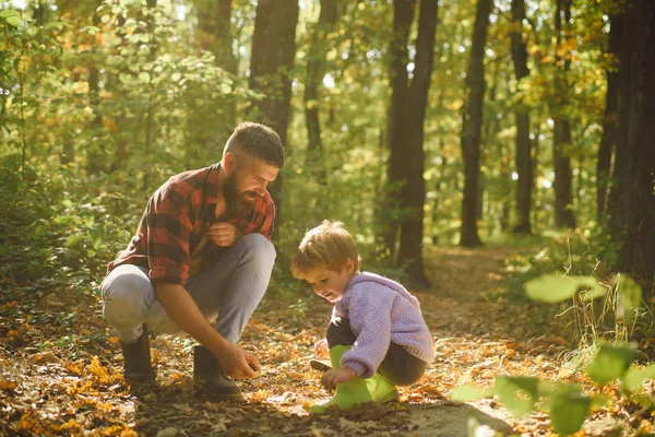 Gülen ve having fun Sonbahar Park baba ve çocuk evlat. Ormanda yürüyüş sırasında babası ile şirin küçük çocuk. — Stok fotoğraf
