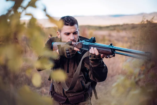 Chasseur visé fusil dans la forêt. Chasseur avec fusil de chasse en chasse. Repérage . — Photo