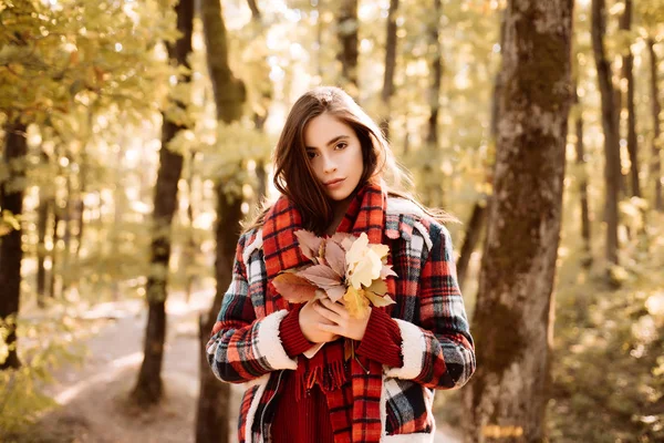 Belle jeune fille heureuse avec une feuille rouge-jaune vif dans le parc. Feuilles et arbres jaunes. Parc d'automne. — Photo