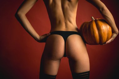 Mutlu Cadılar Bayramı için sihir sırlarını. Kabak üzerinde poz seksi eşek kadın var. Seksi modeller poz içinde iç çamaşırı Cadılar Bayramı arka plan üzerinde. Cadılar Bayramı için en popüler şeker. Cadılar Bayramı seksi kavramı.