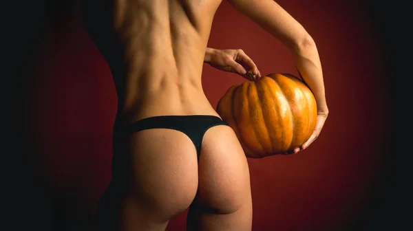 Autumn time for Fashion sale. Night Party background. Halloween poster with pumpkins. Copy space for text. The Most Popular Candy for Halloween. Woman shows a beautiful ass or butt. — Stock Fotó