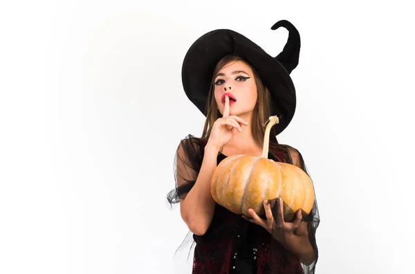 Mulher surpresa bonita em chapéu de bruxas e traje - mostrando produtos. Retrato da Mulher de Halloween. Conceito de Halloween. Elegante charmoso tímido brincalhão perigoso misterioso assustador beleza feminina . — Fotografia de Stock
