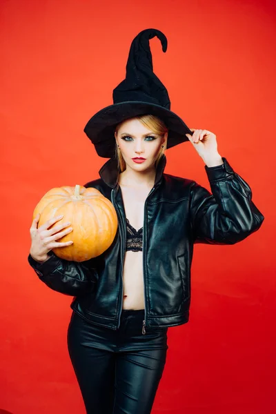 Boldog gótikus fiatal nő boszorkány halloween jelmez. Boszorkány pózol a sütőtök. Halloween koncepció. — Stock Fotó