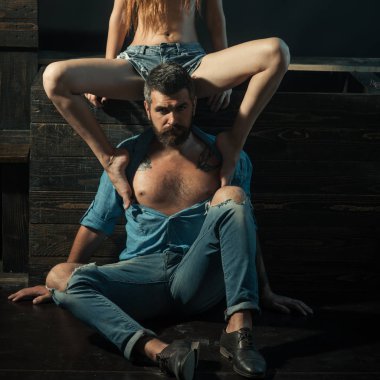 Kot moda ve moda. Erkek ve kadın giyim. Güzel çift retro arka planda kot elbise giyiyor. Şehvetli kadının bacakları meme acımasız erkeklerde. İyi görünümlü çift denim.
