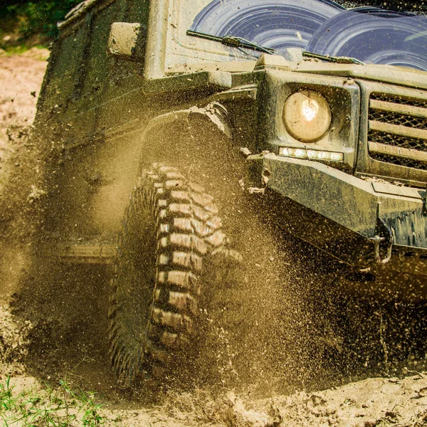 Geländefahrten auf der Bergstraße. Reisekonzept mit großem 4x4-Auto. Schlamm und Wasser plätschern bei Offroad-Rennen. Bewegungs- und Machtkonzept. — Stockfoto