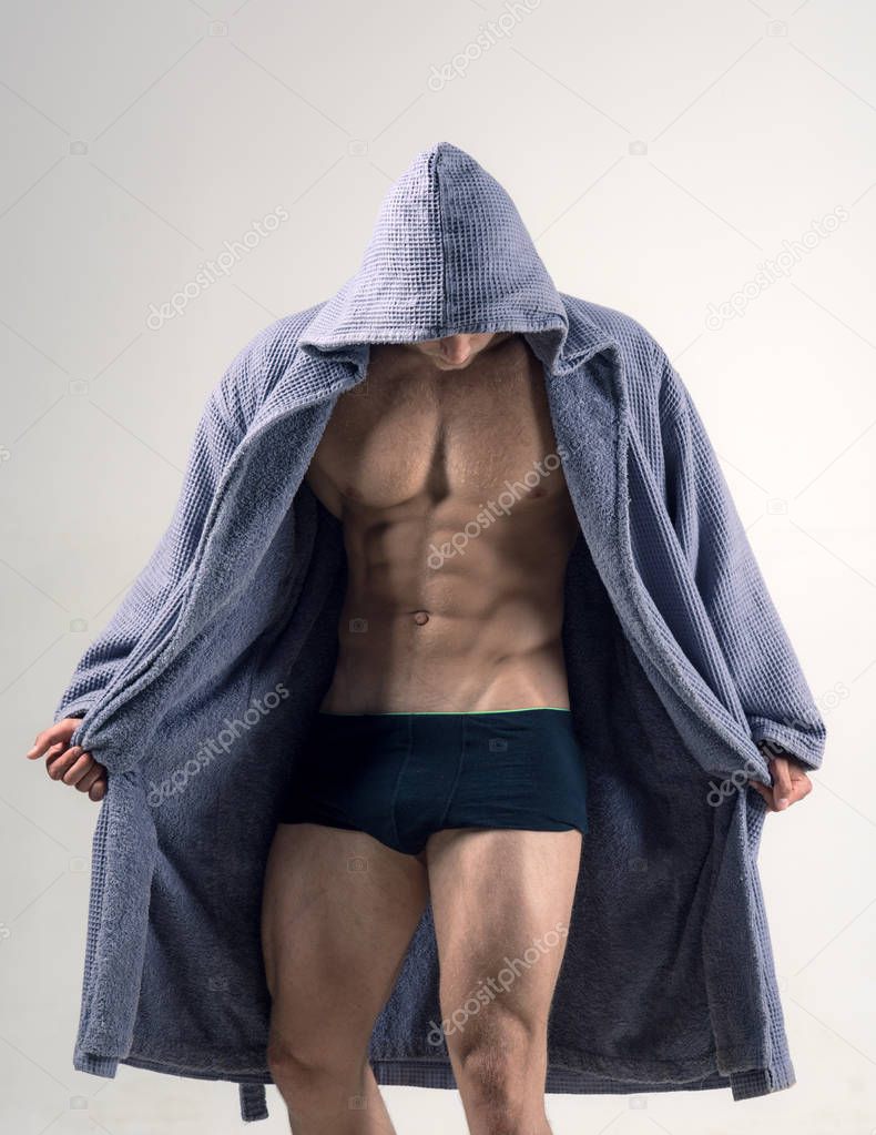 Muscular male model in underwear. Gay man in the morning after training. Spotlife and healthy concept. Man underwear and bathrobe. Muscular man concept.