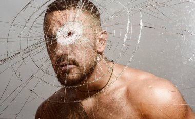 Dövüşmek. Vücuduna yumruk atan bir adam. Çıplak gövdeli, kaslı, seksi bir adam. Kendine güvenen ve yakışıklı bir vahşi. Havalı seksi adam başka tarafa bakıyor..