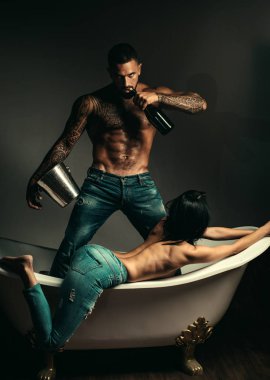 Şampanya güzel kadın için. Şarap Festivali kavramı. Dövmeli vücut yakışıklı adam. Yakışıklı acımasız adam gri arka plan üzerinde. MUDE erkek modeli ile çıplak