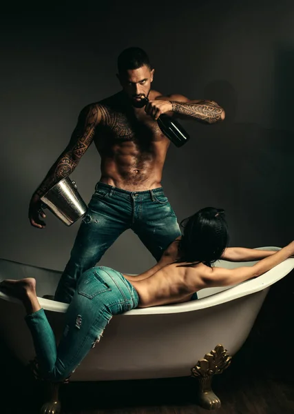 Champanhe para mulher bonita. Conceito de festival do vinho. Um homem bonito com o corpo tatuado. Bonito homem brutal com fundo cinzento. Mude modelo masculino com nu — Fotografia de Stock