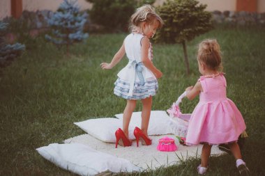 Sisters şık elbiseler yeşil çim çim üzerinde çal
