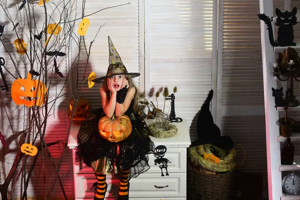 Kleine heks met Halloween decor. Kid in heks hoed — Stockfoto