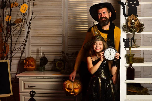 Pai e menina com despertador esperam o Halloween chegar em breve. Menina e pai vestidas para a festa de Halloween. Está na hora de celebrar. Vais ter muito medo em breve. — Fotografia de Stock