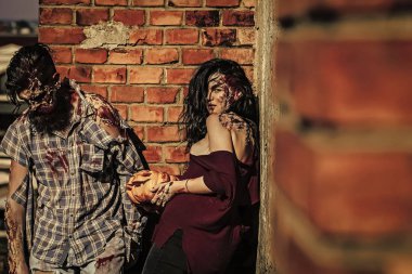 Zombi birkaç sakallı adam hipster veya savaş asker ve kanlı yaralar olan kadın ve Cadılar Bayramı Balkabağı açık havada tuğla duvar ile kırmızı kan