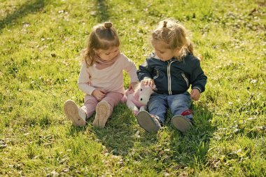 Kız ve erkek yeşil çimenlerin üzerinde oturmak