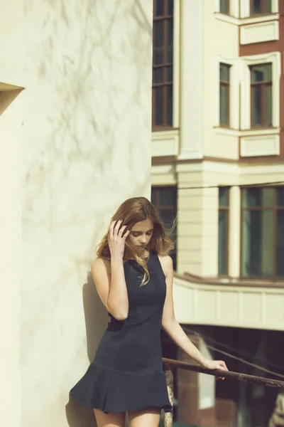 Pretty girl in black dress on balcony — Stock Photo, Image