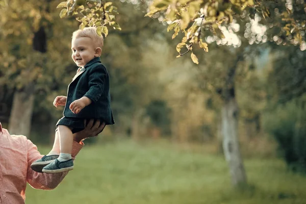 Linda sonrisa de niño en traje, camisas, zapatillas bajo el árbol, moda — Foto de Stock