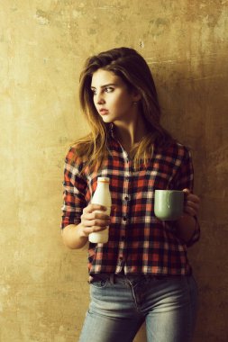 Güzel kız şişe ve bardak kefir ile tutarak