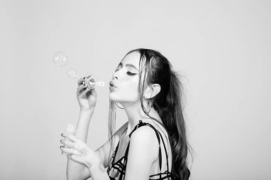 Kadın pembe studio arka plan üzerinde kabarcık üfleyici ile