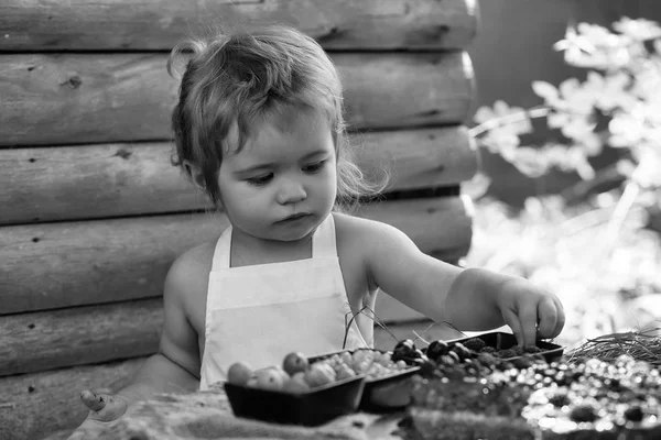Маленький хлопчик їсть червону малину — стокове фото