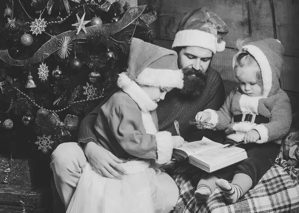 圣诞帽上有胡子的父亲和孩子的家庭 — 图库照片