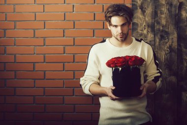 sakallı adam kutusunda mevcut olarak kırmızı gül çiçekler tutar