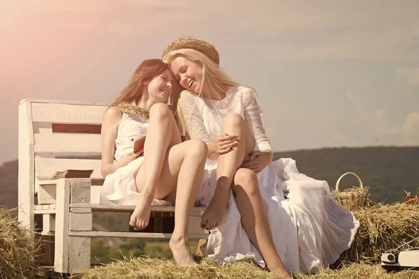 Δύο κορίτσια που κάθεται στον πάγκο στο σανό — Φωτογραφία Αρχείου