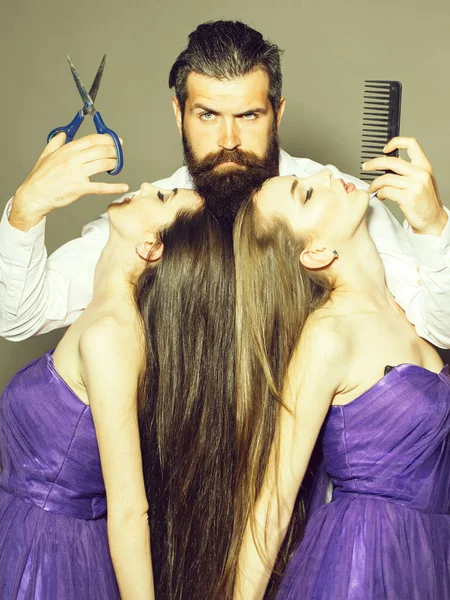 Бородатый мужчина парикмахер и две женщины — стоковое фото
